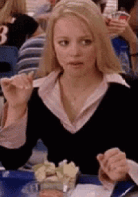 a woman is sitting at a table with a plate of food in front of her .