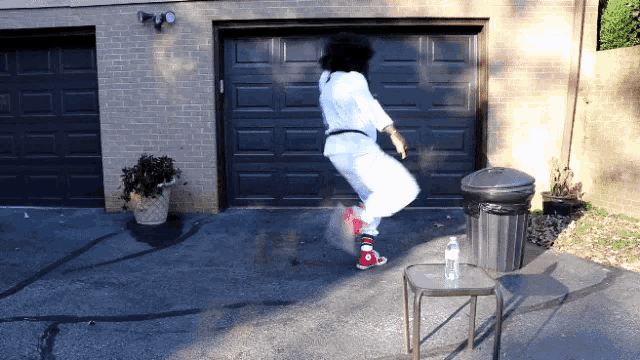 a person jumping in the air in front of a garage door