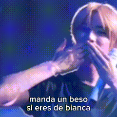 a woman singing into a microphone with the words manda un beso si eres de bianca written below her