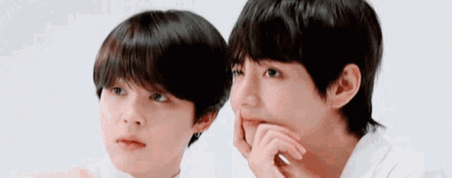 a couple of young men are standing next to each other and looking at each other .