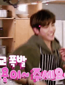 a man in an apron is dancing in a kitchen with a sign that says ' i love you ' on it .