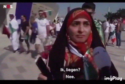 a woman in a hijab is talking into a microphone while holding a cell phone .