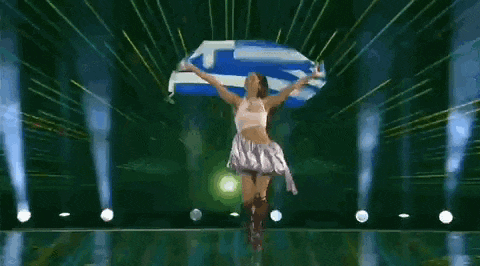 a woman is holding a blue and white greek flag