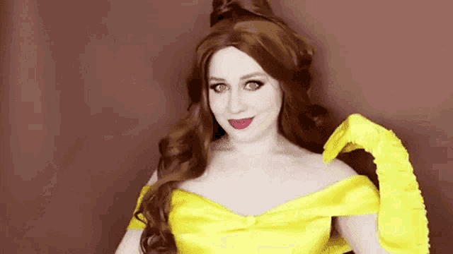 a woman is dressed as belle from beauty and the beast and wearing a yellow dress .