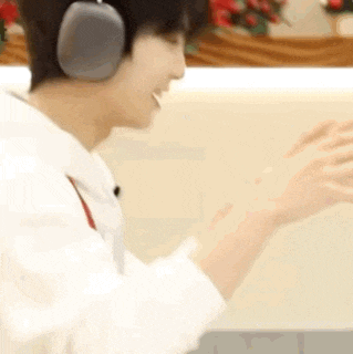 a man wearing headphones is sitting in front of a computer screen .