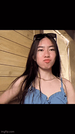 a young woman wearing sunglasses and a blue dress makes a funny face