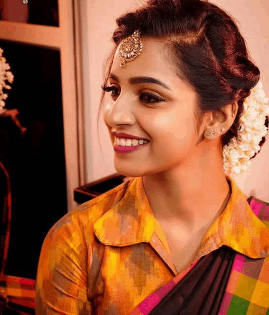 a woman wearing a yellow shirt and a flower in her hair