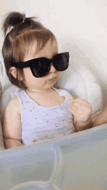 a baby wearing sunglasses and a tank top