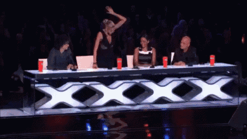 a group of people are sitting at a table with a large x on it