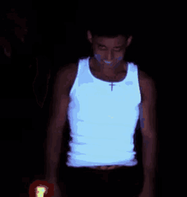 a man in a glow in the dark tank top with a cross on his chest