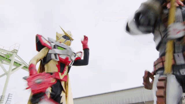 a man in a costume is standing next to a robot and holding a sword .