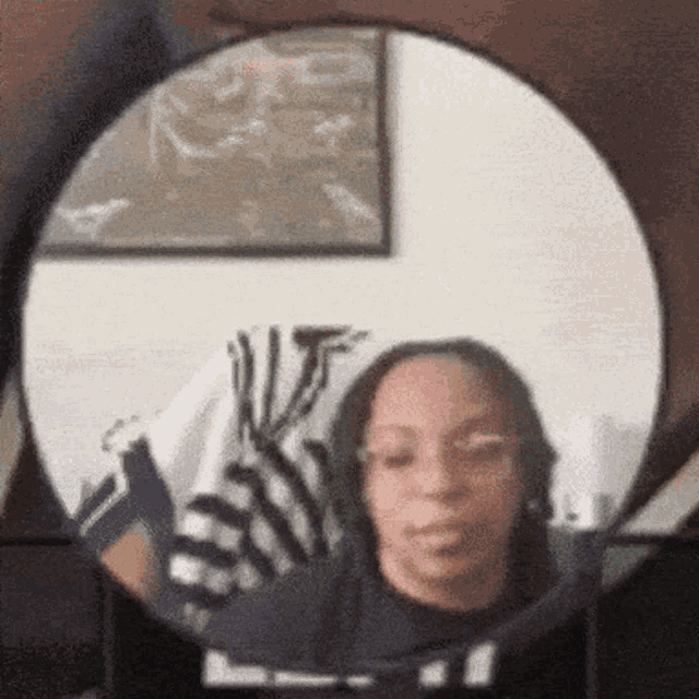 a woman taking a picture of herself in a round mirror