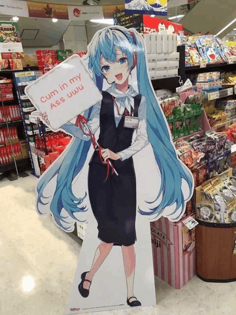 a cardboard cutout of a girl holding a sign that reads cum in my ass uwu