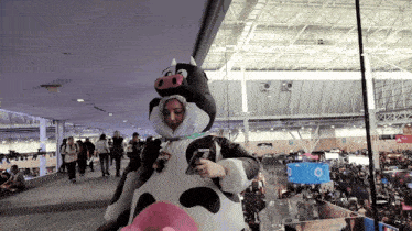 a woman in a cow costume is holding a phone