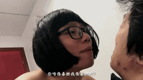 a woman wearing glasses and a wig looks at a man 's face