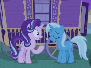 two ponies standing next to each other in front of a house