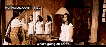 two women are standing in front of a mirror talking to each other and one of them is asking what 's going on here .