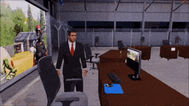 a man in a suit and tie is standing in front of a computer