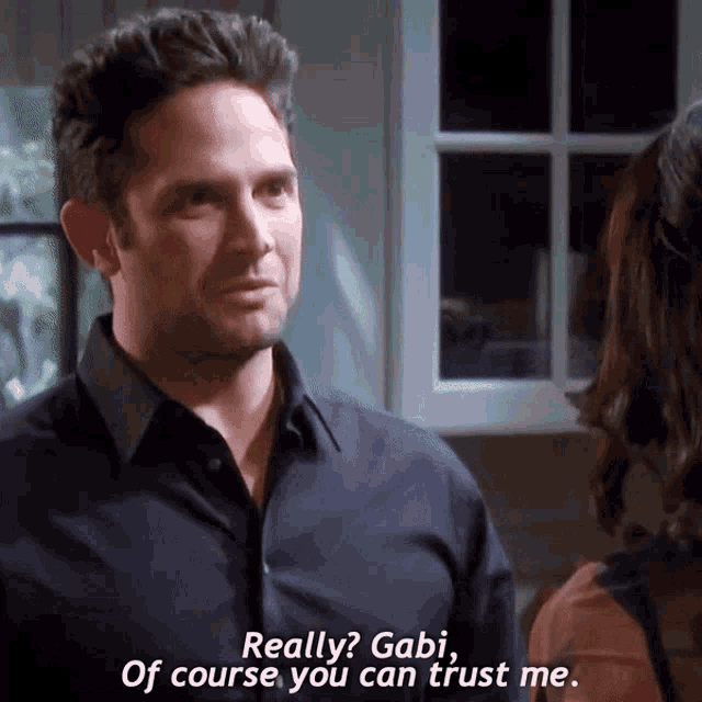 a man in a black shirt is talking to a woman in a kitchen and says " really gabi of course you can trust me "