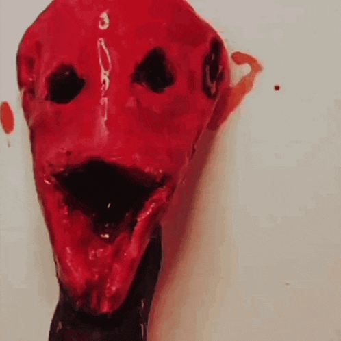 a close up of a red face with blood coming out of it 's eyes