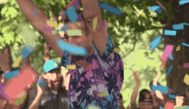 a man in a purple shirt is celebrating with confetti
