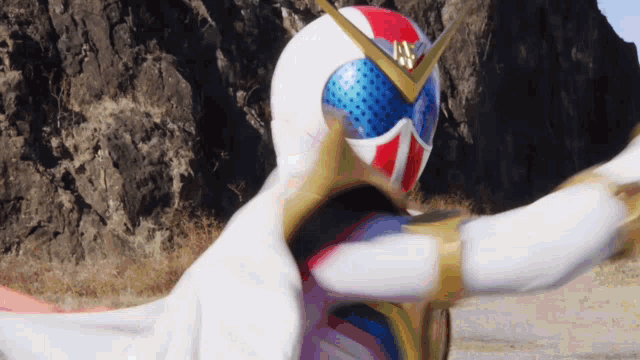 a person in a white and red superhero costume is standing in front of a mountain