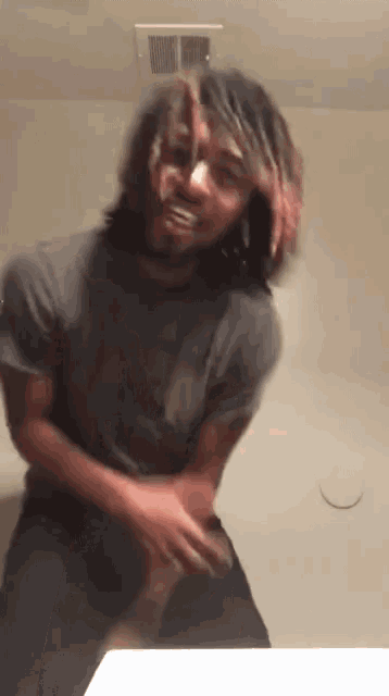 a man with long hair is standing in front of a mirror