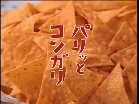 a close up of a pile of nachos with chinese writing in the background