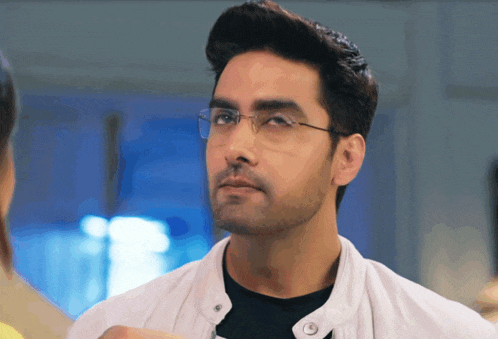 a man wearing glasses and a white jacket
