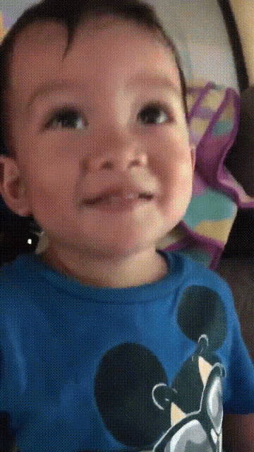 a baby is wearing a blue shirt with mickey mouse on it