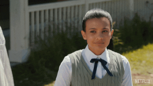 a girl in a school uniform is standing in front of a white house with netflix written on the bottom