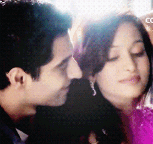 a man and a woman are looking at each other and the woman is wearing earrings