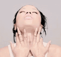a woman with her eyes closed and her hands on her neck