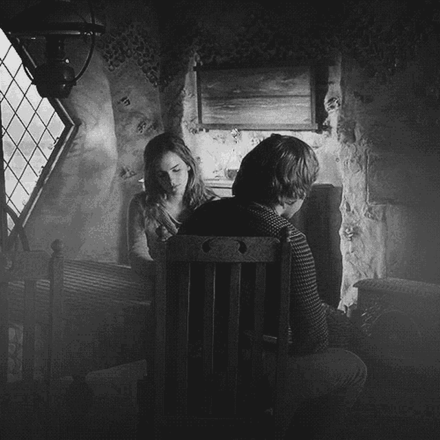 a black and white photo of a man and a woman in a room