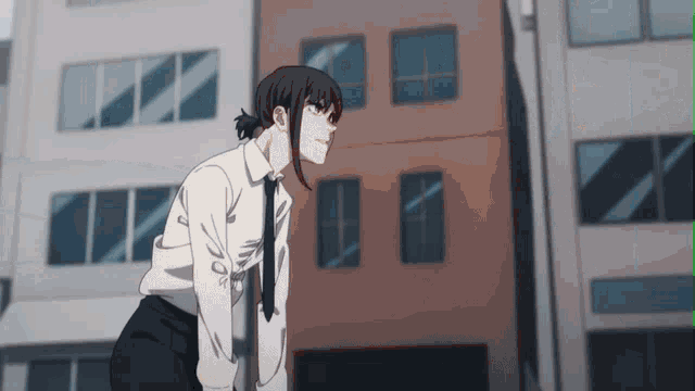 a woman in a white shirt and black tie is standing in front of a building