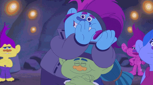 a group of trolls are hugging each other and one has purple hair