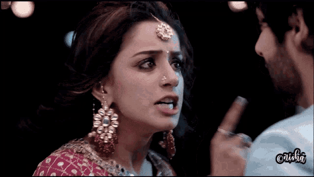 a close up of a woman 's face with a man 's hand behind her and the word anisha on the bottom