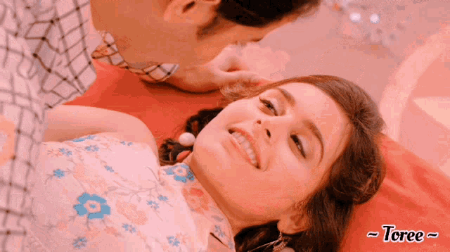 a man kissing a woman 's forehead with the word toree below it