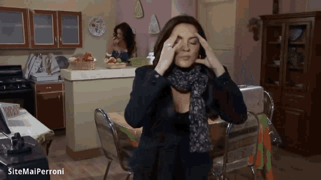 a woman with a scarf around her neck is holding her head in pain