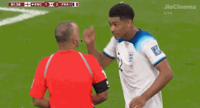 a soccer player with the number 19 on his jersey talks to another player