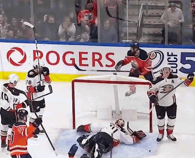 a hockey game is being played in front of a rogers banner