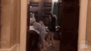 a group of people are standing in a room in a house .