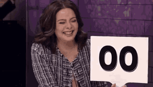 a woman is smiling while holding a sign that says 00 .