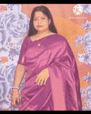 a woman in a purple saree is standing in front of a floral backdrop