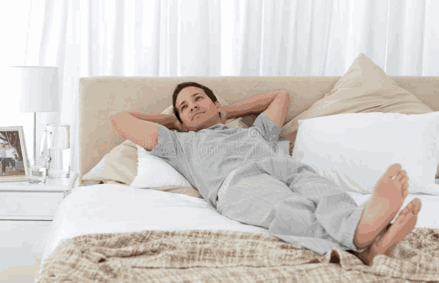 a man is laying on a bed with his feet up