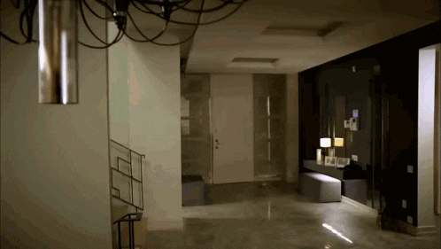 an empty hallway with a staircase and a lamp