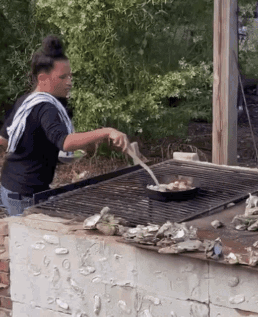 a woman is cooking food on a grill outdoors