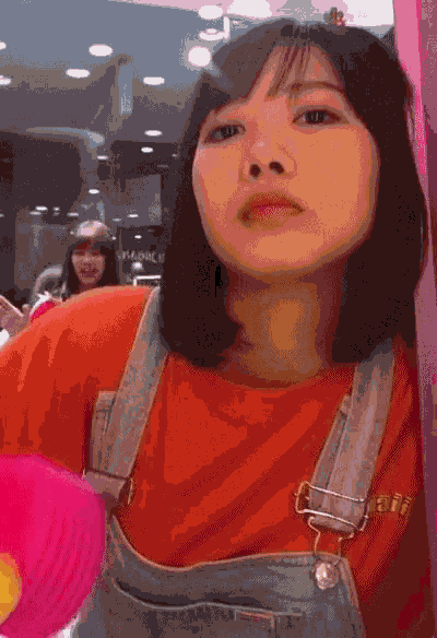 a girl wearing overalls and an orange shirt with the word abercrombie on it