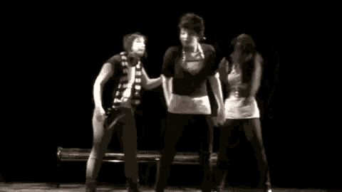 a black and white photo of a group of people dancing on a stage