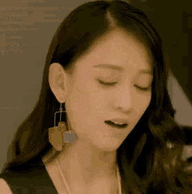 a woman wearing earrings is making a funny face .